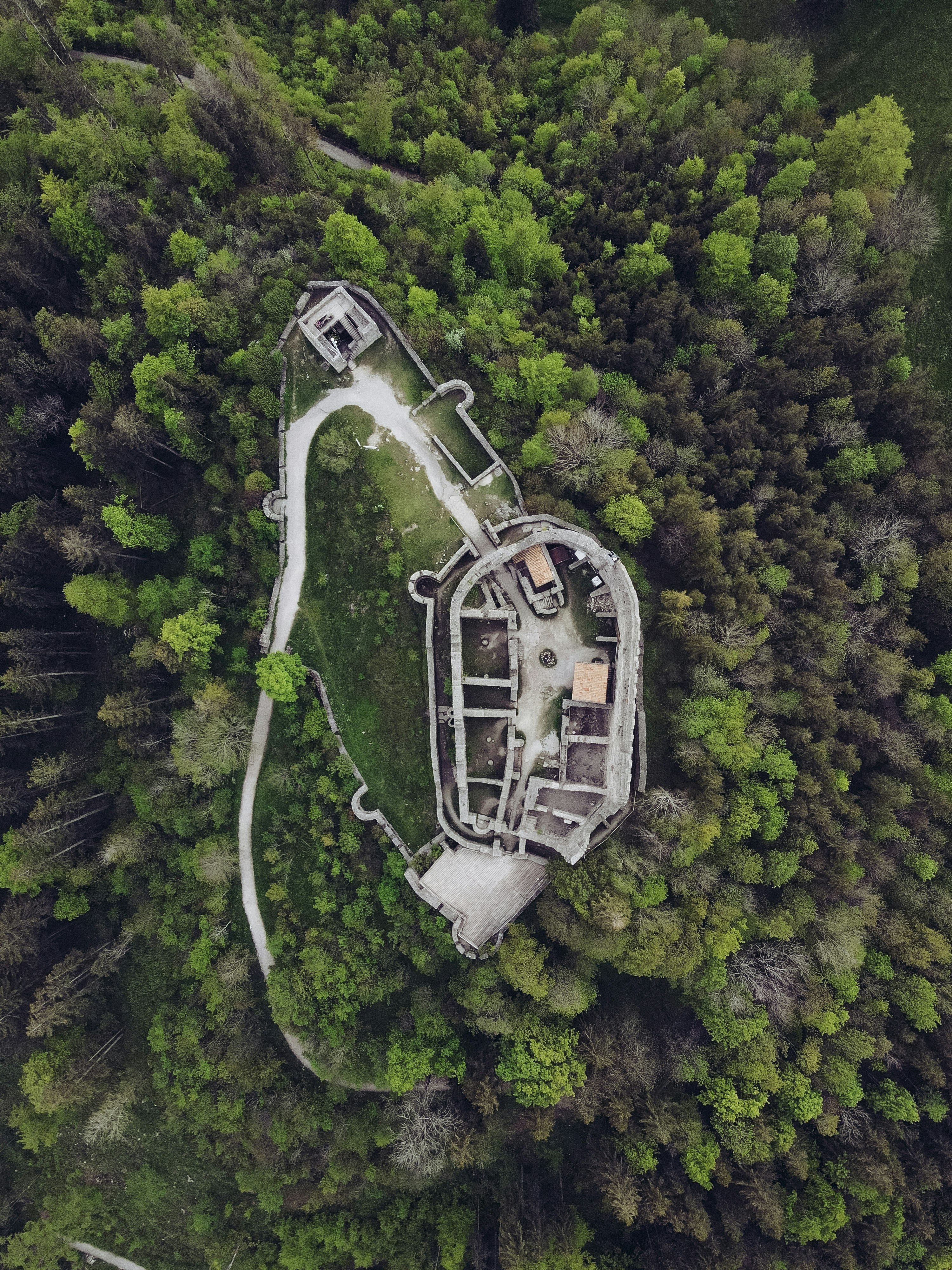 aerial view of white and gray building on green forest during daytime